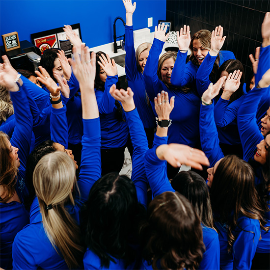Team grouped with hands thrown in air after a team huddle