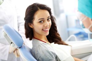 smiling-young-woman-seated-at-orthodontic-appointment