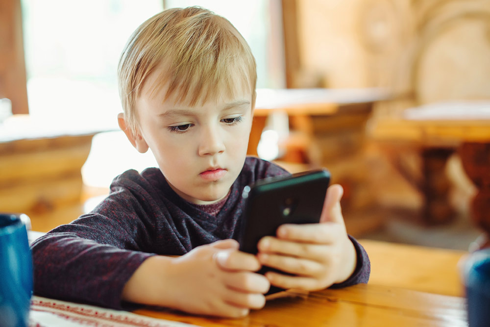 Young boy playing games on a mobile device