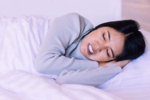 Young woman with bruxism sleeping uncomfortably | Dr. Alyssa Orthodontics Sherman, TX