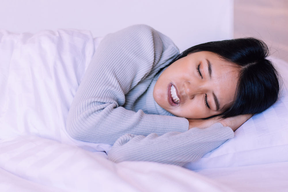 Young woman with bruxism sleeping uncomfortably | Dr. Alyssa Orthodontics Sherman, TX